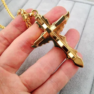 Ornate 18K gold plated hip hop cross pendant necklace for men shown in hand detail