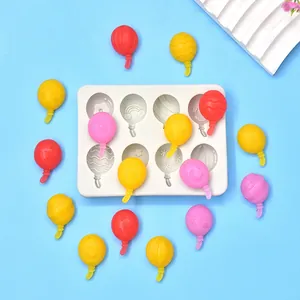 Detailed top view of 8-cavity balloon silicone mold with colorful molded items on blue.