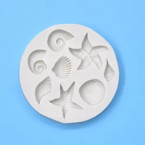 Detail view of various sea shell and starfish shapes in the white silicone mold.