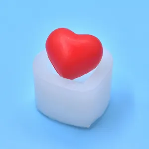 Detailed view of a heart-shaped silicone mold with a finished red heart model.