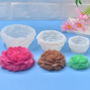 Vista macro di tre stampi in silicone a forma di peony di diverse dimensioni con saponi.