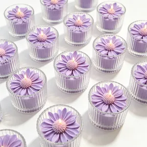 Detalle de velas aromáticas con forma de margarita lila en tarros