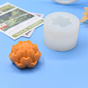 Detailansicht einer Lotusblüten-Silikonform und fertigen orangefarbenen Duftkerze im Bastelstil.