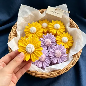 Vista detallada de velas aromáticas con forma de margarita hechas a mano.