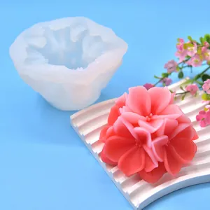 Detailed view of floral silicone mold and finished pink flower shaped candle for DIY crafts
