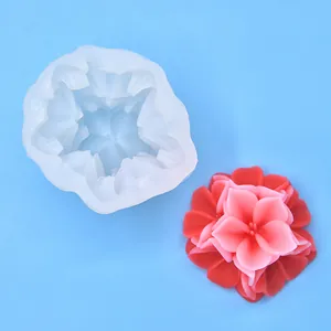 Detail view of 3D flower silicone mold alongside a finished red wax candle ornament