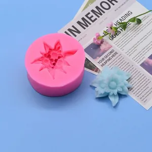 Flower-shaped silicone mold displayed with a finished light blue gypsum blossom on blue background
