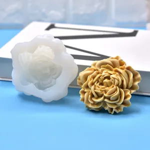 Gedetailleerd zicht op een 3D-bloem siliconen mal met een afgewerkte gele bloemenkaars.