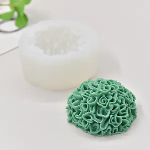 Detailed close-up of marigold flower silicone mold with finished green wax candle