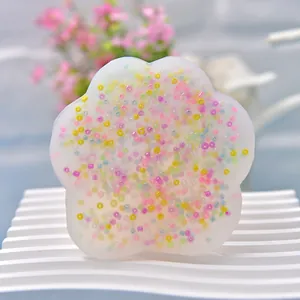Nahaufnahme einer blumenförmigen Silikonform mit bunten eingebetteten kleinen Perlen