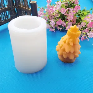 Detailed view of a white silicone mold and the finished orange Christmas tree candle