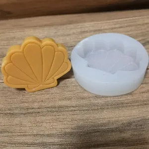 Molde profesional de silicona de concha con una vela decorativa amarilla terminada