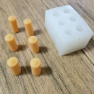 Macro view of 6-hole mini scented candle silicone mold with finished wax cylinders
