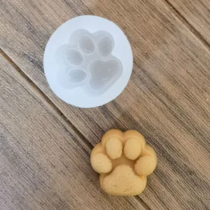 Vista detallada del molde de silicona con forma de pata de gato y vela amarilla