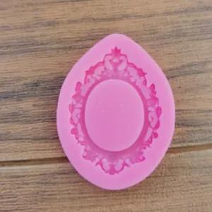 Close-up view of a pink silicone mold featuring a vintage European relief frame pattern for baking
