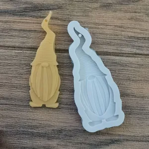 Detailed view of a gnome silicone mold and finished resin pendant on rustic wood background