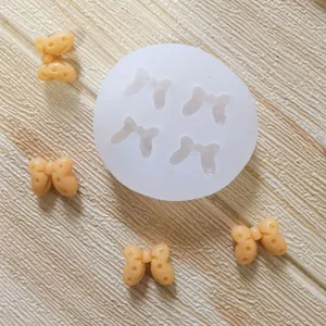 Silicone bow mold for fondant and chocolate cake decor with finished peach-colored bows.