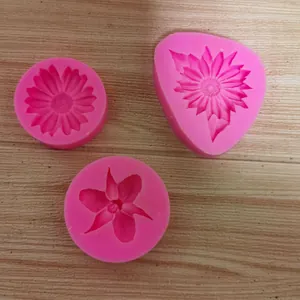 Detailed macro view of three different pink silicone flower molds for fondant and clay