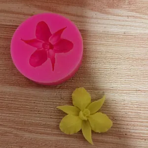 Detail view of a pink flower silicone mold with a yellow fondant model