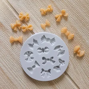 Detailed view of white silicone mold with finished bow-shaped cake decorations