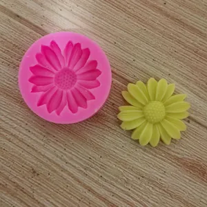 Macro view of pink flower silicone mold with finished yellow fondant daisy detail