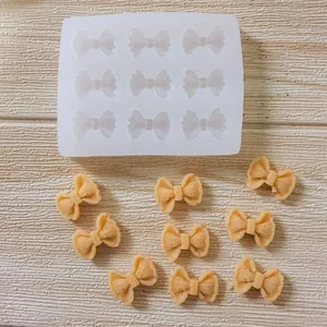 Close-up detail of bow-tie silicone mold with finished decorative fondant pieces