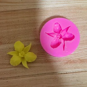 Professional pink flower silicone fondant mold shown with a finished yellow flower decor