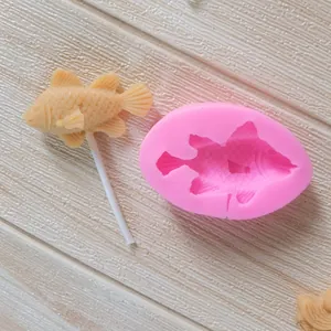 Vue détaillée d'un moule en silicone poisson avec une sucette sur un fond en bois