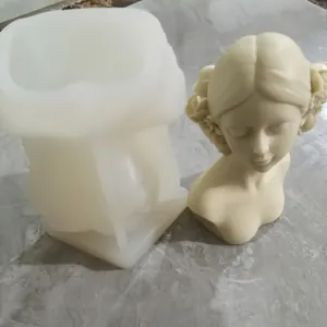 Detailed macro view of white silicone girl bust mold with a finished beige plaster sculpture