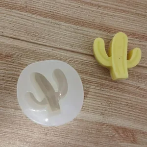 Gros plan d'un moule en silicone cactus avec un échantillon de bougie en jaune.