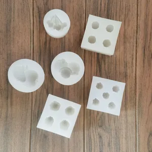 Macro view showing a collection of white fruit-shaped silicone molds on a wooden floor