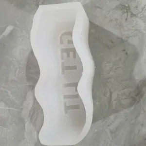 Close-up of a white wavy silicone mold featuring embossed GET LIT phrase for DIY