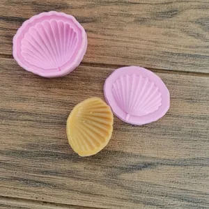 Vista dettagliata di stampi in silicone a conchiglia con cioccolato finito su legno