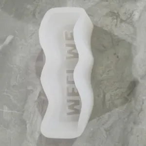 Macro detail of white wavy silicone candle mold with internal WEEKEND text relief