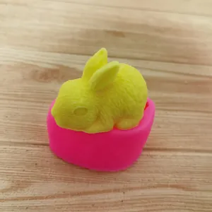 Dettaglio di una figura di coniglio giallo in stampo di silicone rosa DIY