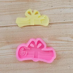 Detailweergave van de roze siliconenvorm en de resulterende gele fondant diploma-rol