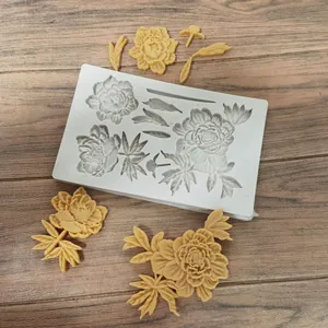 Detailed view of peony flower silicone mold with yellow fondant floral samples on wood background.