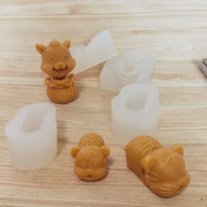 Vue détaillée des moules en silicone tigre 3D et des pièces finies sur fond de bois.