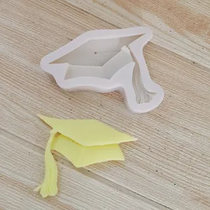 Detailopname van een siliconenvorm voor een afstudeerhoed met een geel fondantstuk.