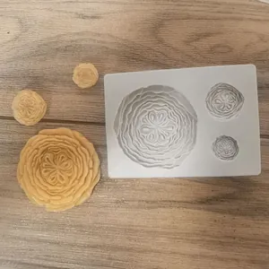 Macro detail view of white flower silicone mold and yellow soap petals on wood background