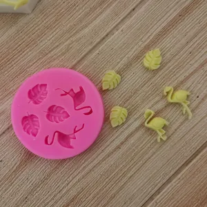Macro view of pink silicone flamingo and monstera leaf cake decoration mold