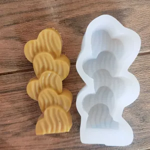Vue détaillée du moule en silicone cœur ondulé avec pièce de cire jaune finie