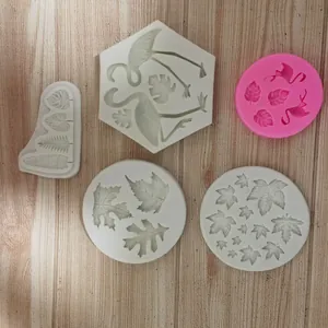 Detail view of five silicone cake molds featuring maple leaf and flamingo designs.