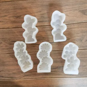 Vue détaillée de cinq moules en silicone blancs avec marguerites et cœurs pour DIY.