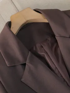 Vista macro dettagliata del rever di un blazer marrone scuro con fodera interna di qualità.