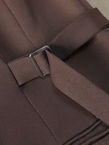 Primo piano di un blazer marrone scuro con fibbia della cintura regolabile in vita