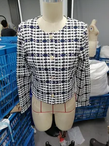 Detail view of a stylish women's cropped houndstooth blazer with elegant gold buttons.