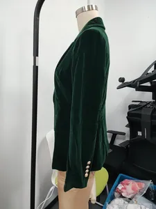 Side view detail of a premium dark green velvet blazer with decorative gold cuff buttons