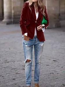 Detail of a chic burgundy velvet blazer jacket styled with trendy ripped jeans