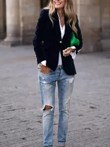 Elegant navy velvet blazer with decorative gold buttons and a vibrant green clutch detail